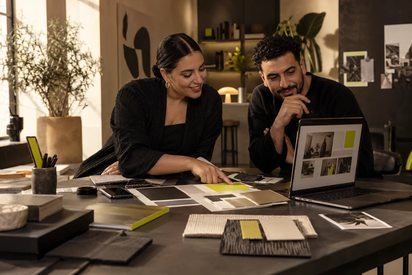 A business owner and strategist combining website, identity and campaign materials at one desk.